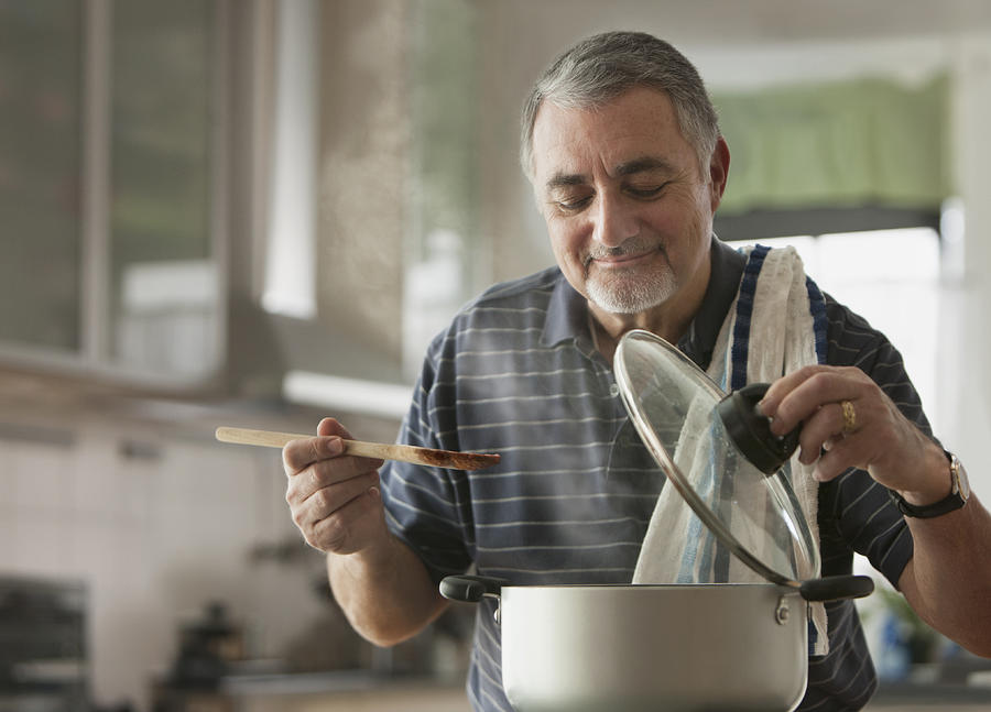 Elderly man cooking Photograph by SelectStock