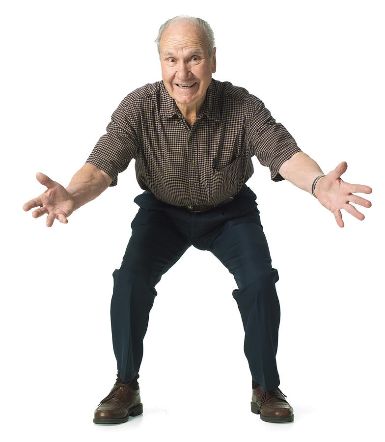 Elderly man crouches down with his arms wide open. Photograph by Photodisc