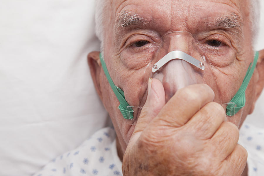 Elderly man wearing oxygen mask Photograph by Vstock LLC