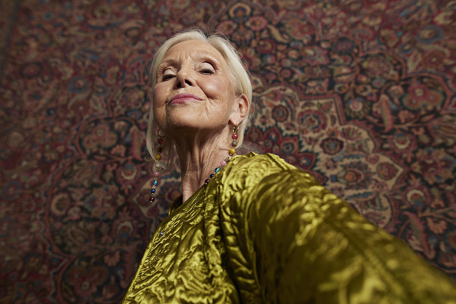 Elderly woman against wall hanging rug Photograph by Klaus Vedfelt Elderly woman against wall hanging rug Photograph by Klaus Vedfelt