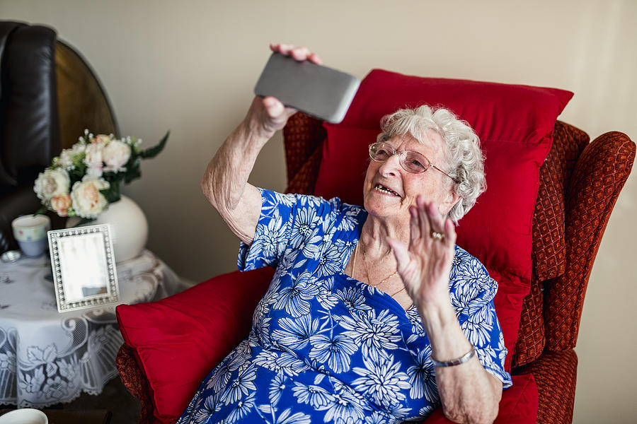 Elderly Woman Using A Mobile Telephone Photograph by SolStock