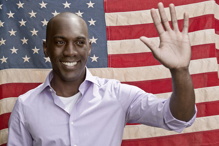 Elected politician waving in front of American flag Photograph by Hudzilla