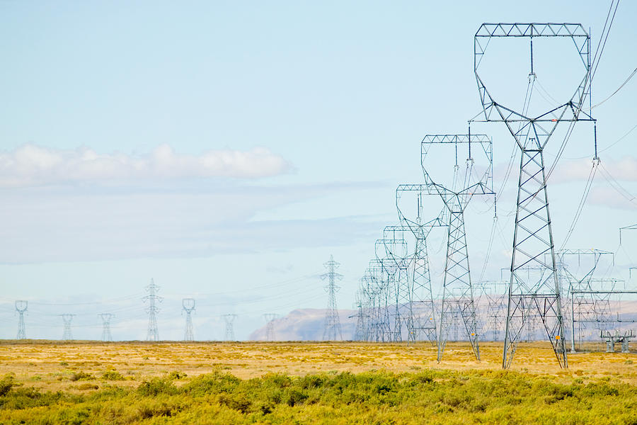 Electrical pylons in field Photograph by George Diebold