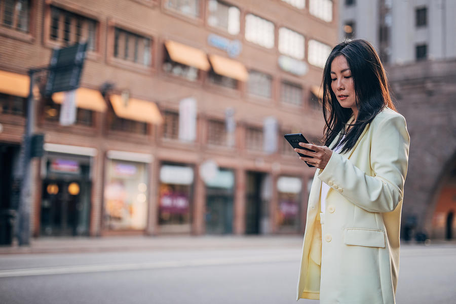 Elegant businesswoman text messaging Photograph by Hirurg