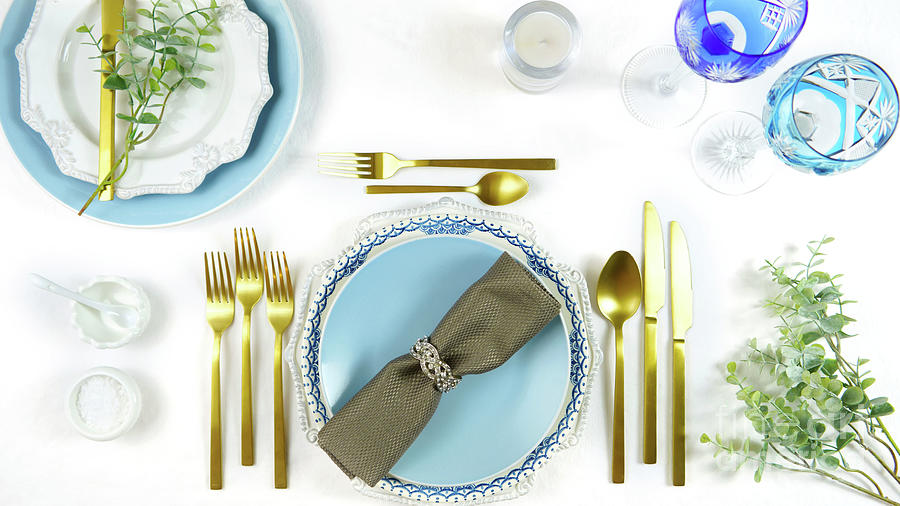 Elegant fine china events table place settings in blue white and gold theme. Photograph by Milleflore Images