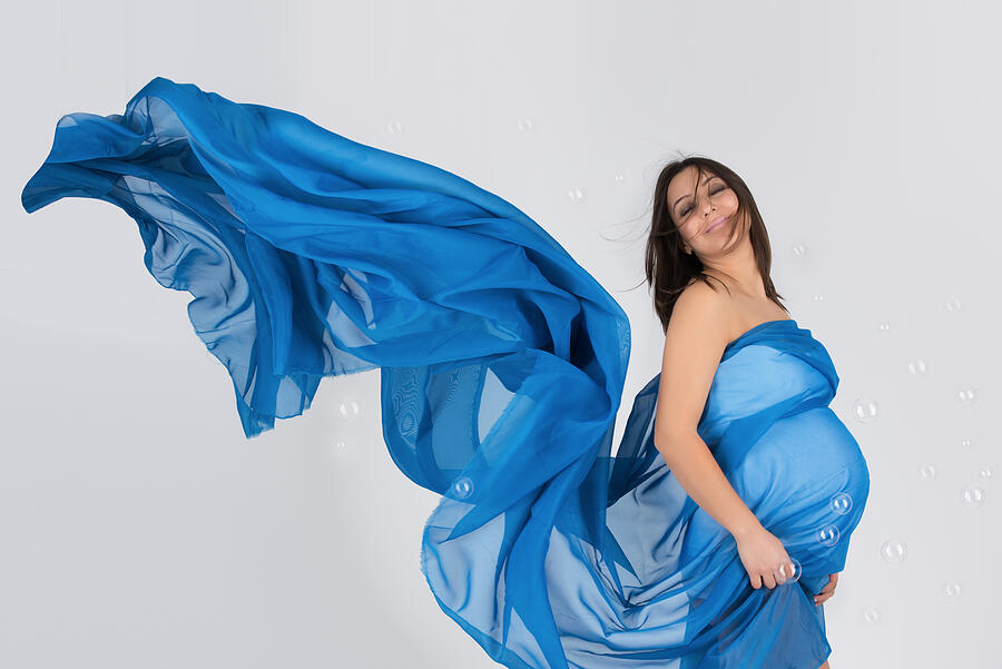 Elegant pregnant mom in wavy blue dress posing Photograph by Bbevren
