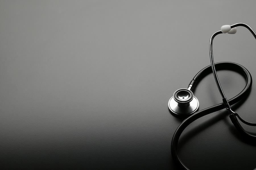 Elegantly coiled stethoscope on dark gray background Photograph by Dny59