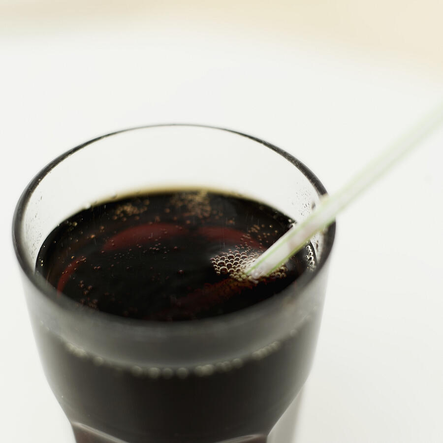 Elevated view of a glass of cola with a straw in it Photograph by Stockbyte