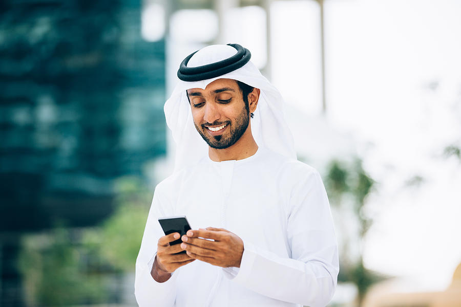 Emirati using a smart phone Photograph by Filadendron