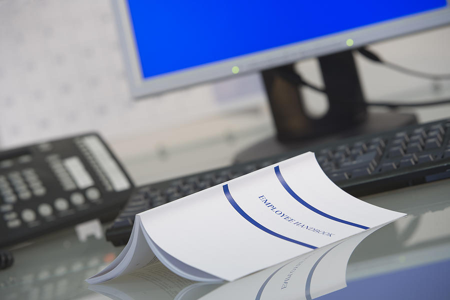 Employee handbook on desk Photograph by Comstock Images
