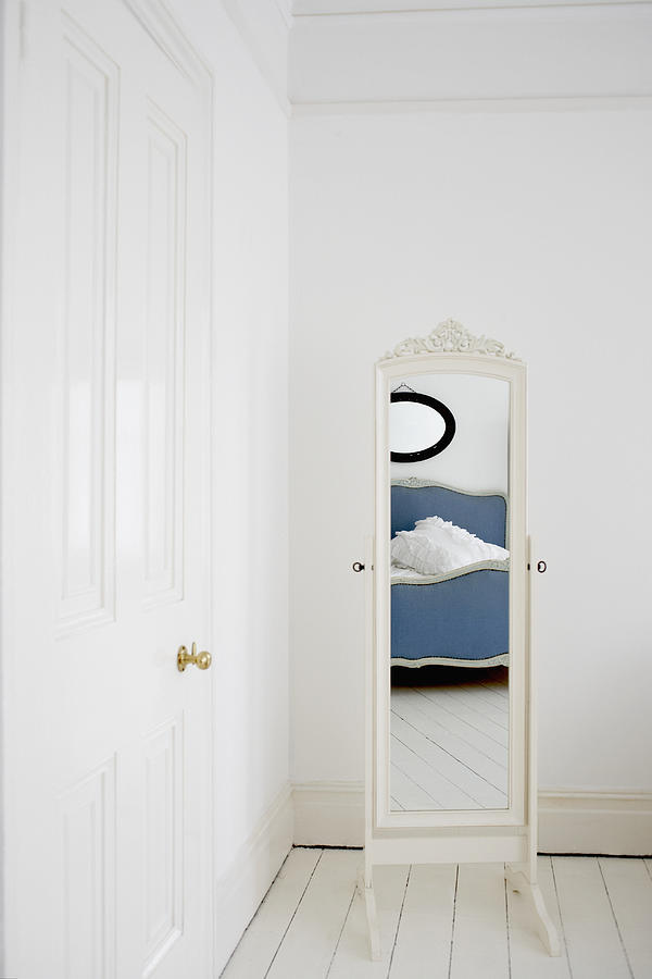 Empty bedroom with mirror and bed Photograph by Martin Barraud