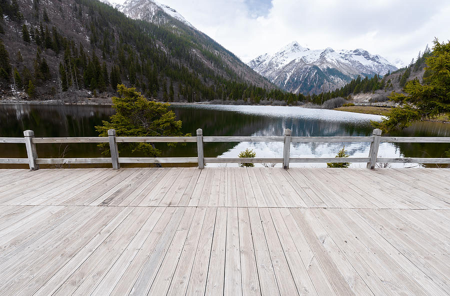 Empty boardwalk with snow mountains Photograph by Xuanyu Han
