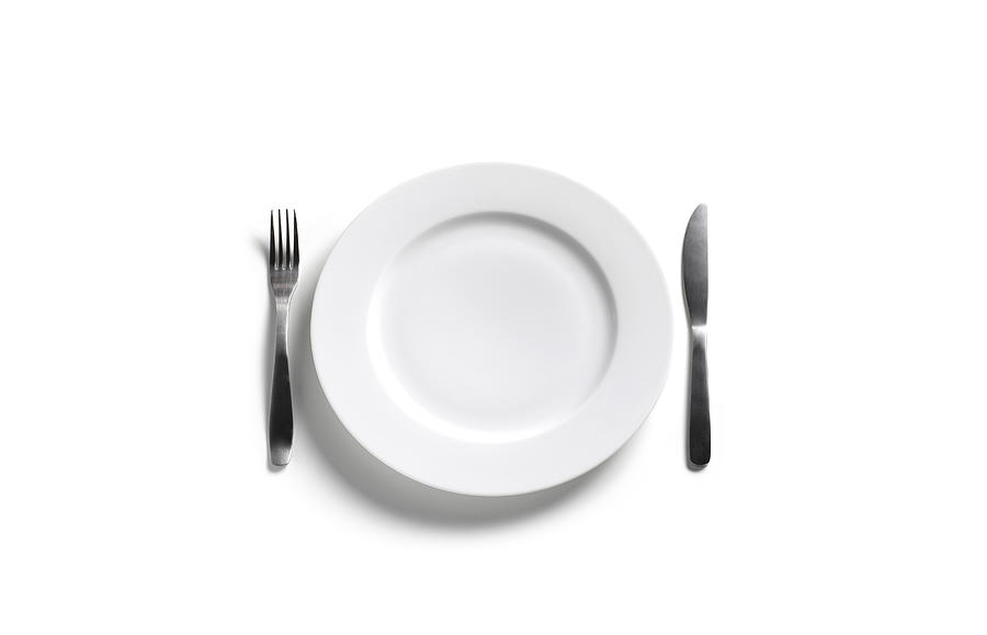Empty dinner plate on white background Photograph by Peter Dazeley