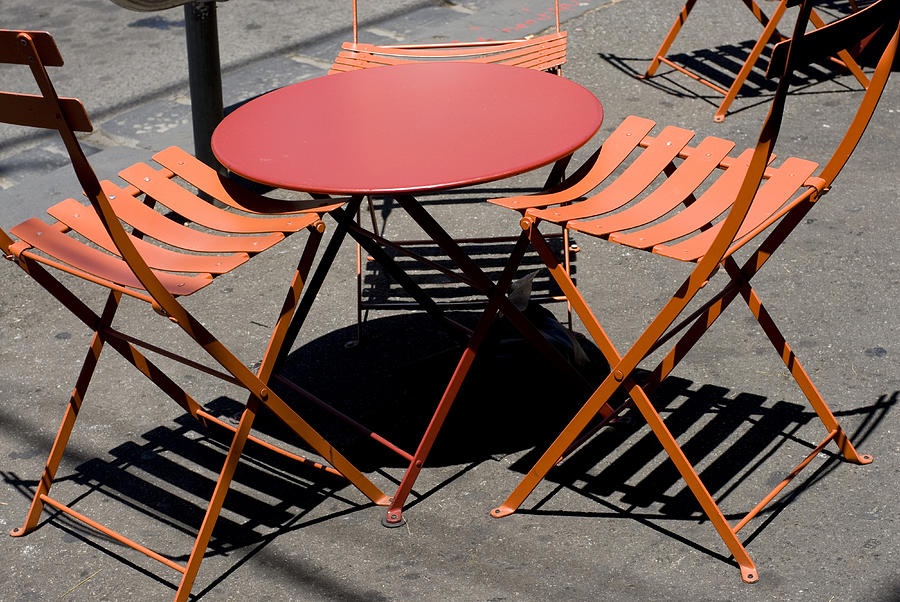 Empty Orange cafe table and chairs with shadows Photograph by Lyn Holly Coorg