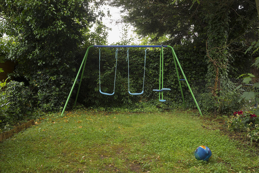 Empty swing set in backyard Photograph by Chris Clor