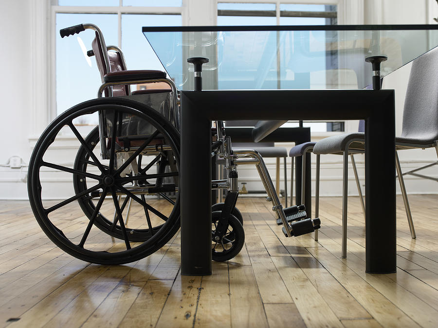 Empty Wheelchair in a Boardroom Photograph by Digital Vision.