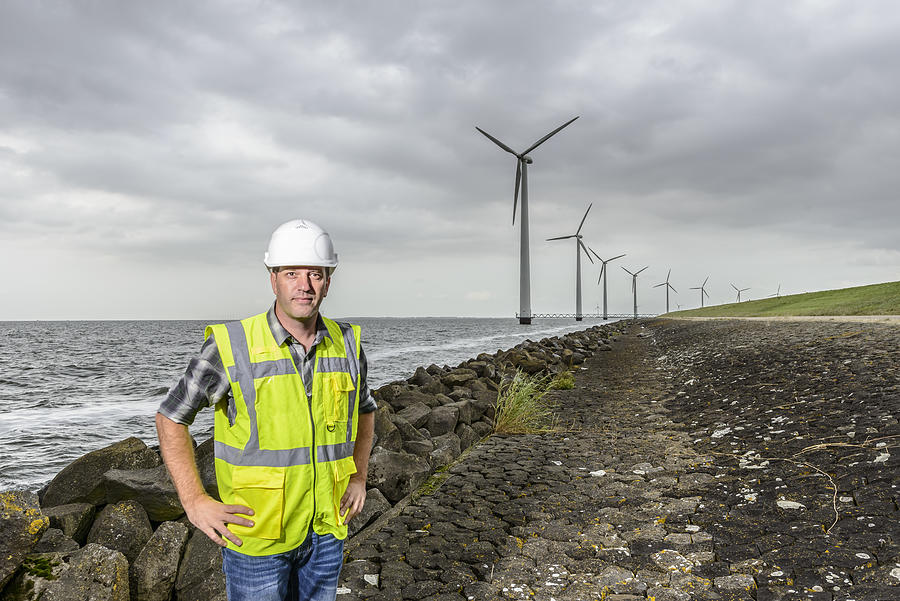 Engineer at an offshore wind turbine park during an overcast day Photograph by Sjo