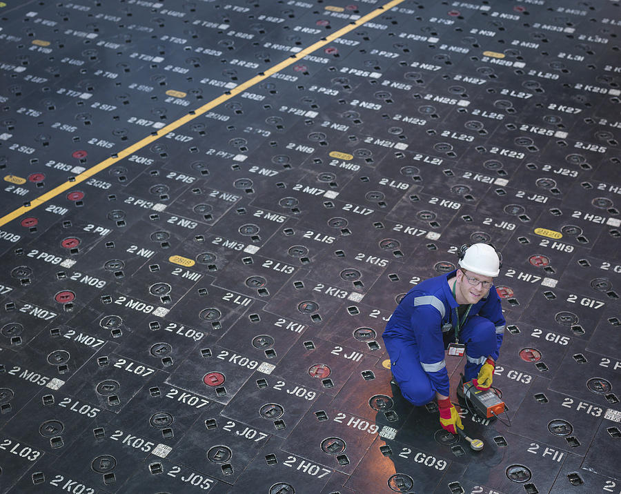 Engineer using sensors on pile cap in nuclear power station, portrait Photograph by Monty Rakusen