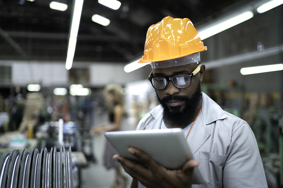 Engineer using tablet and working in factory Photograph by FG Trade