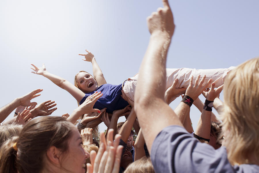 Enthusiastic woman crowd surfing Photograph by Martin Barraud
