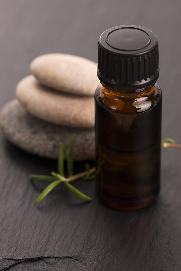 Essential oil with rosemary and fresh green leaves Photograph by Joannawnuk