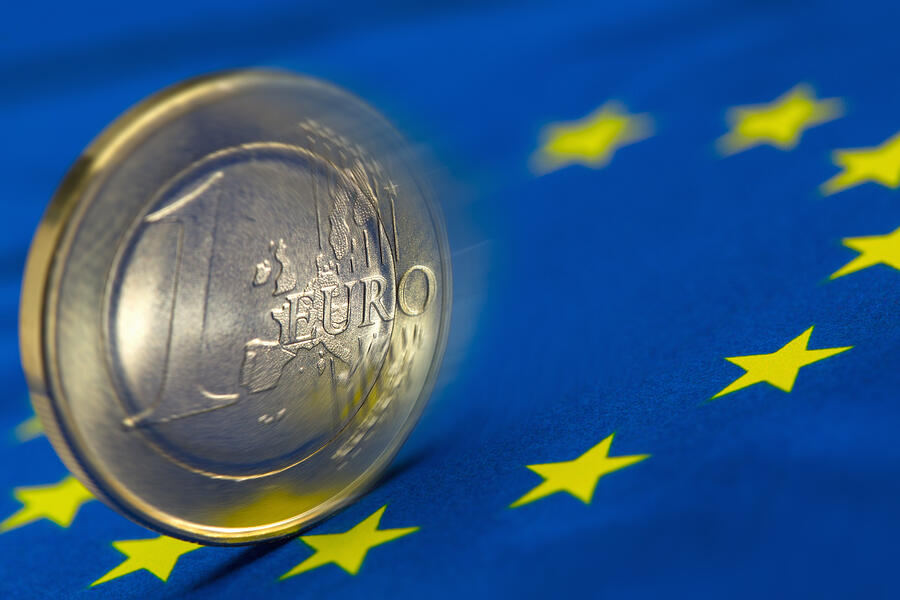 Euro coin rolling on an EU flag Photograph by Siegfried Layda