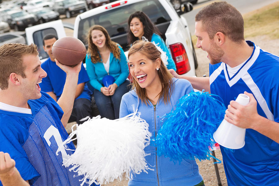 Excited group of friends tailgating at college football stadium Photograph by SDI Productions