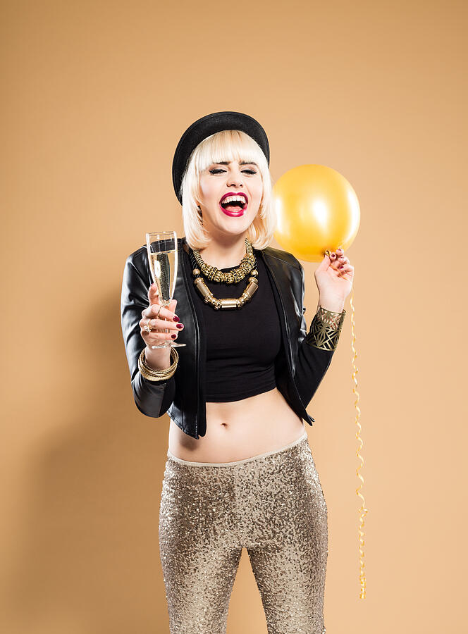 Excited woman holding a glass of champagne and balloon Photograph by Izusek