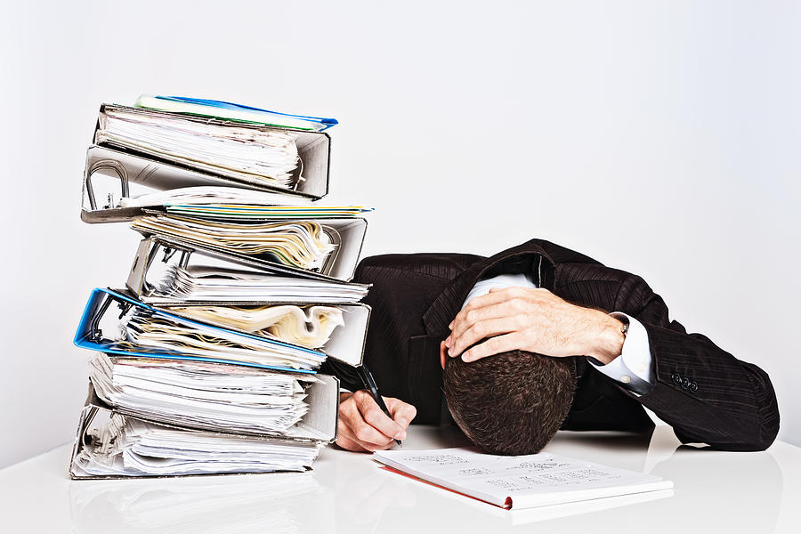 Exhausted businessman with too much work collapses over desk Photograph by RapidEye