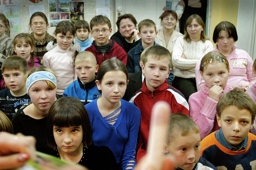 Explaining dipping sticks to Russian orphans Photograph by Robert Dann