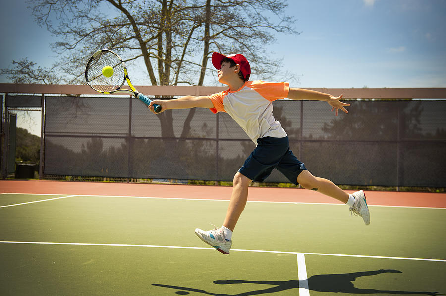 Extended Reach Tennis Forehand By Young Boy Photograph by Stephen Simpson