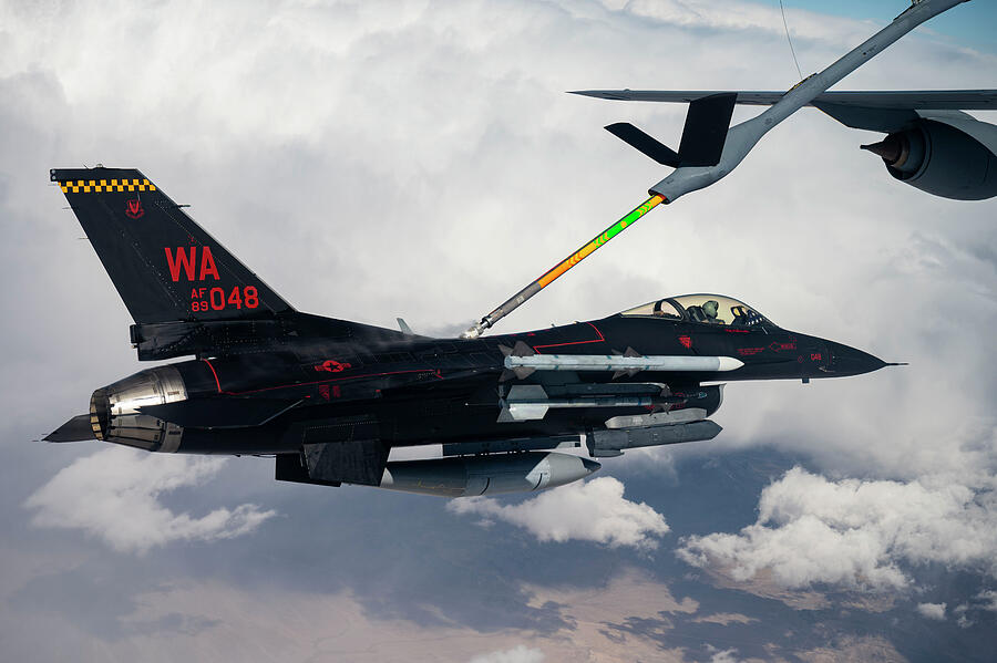 F16 Fighting Falcon receives fuel from a KC-135R Stratotanker Photograph by Lawrence Christopher