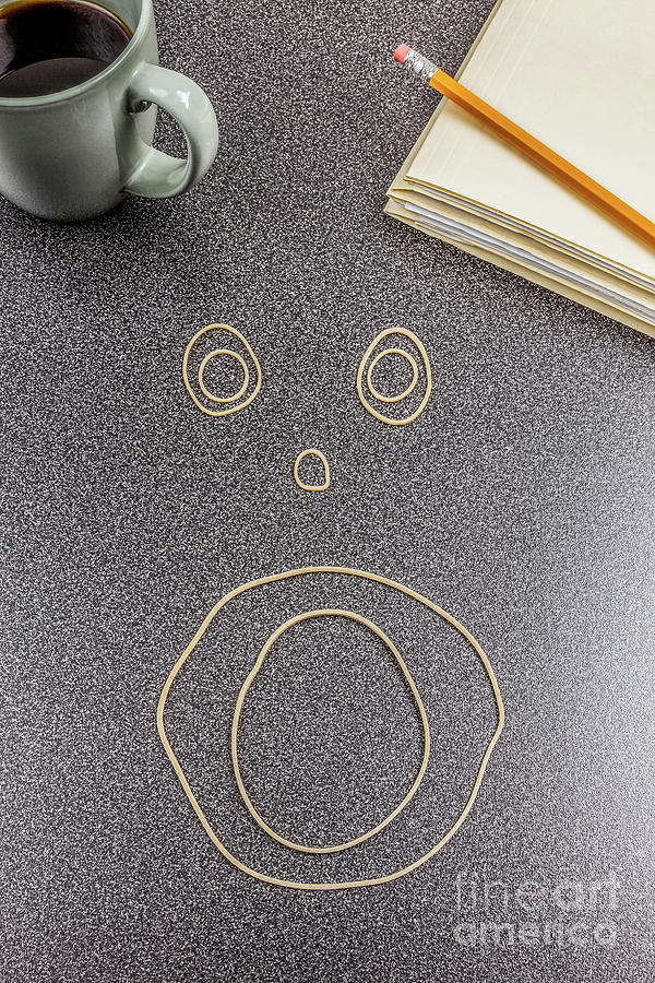 Face made out of rubber bands on office desk Photograph by Bryan Mullennix
