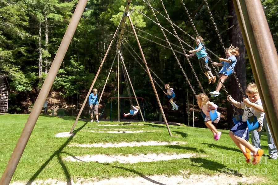 Families swing together on a tall playground swing Photograph by William Kuta