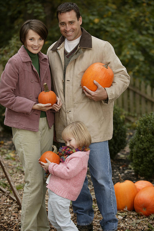 Family carrying pumpkins Photograph by Comstock Images