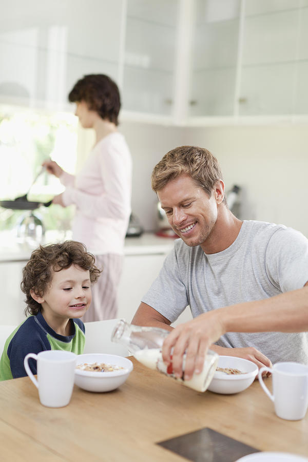 Family eating breakfast in kitchen Photograph by Hybrid Images