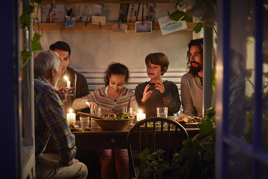 Family having cozy dinner en garden house Photograph by Klaus Vedfelt