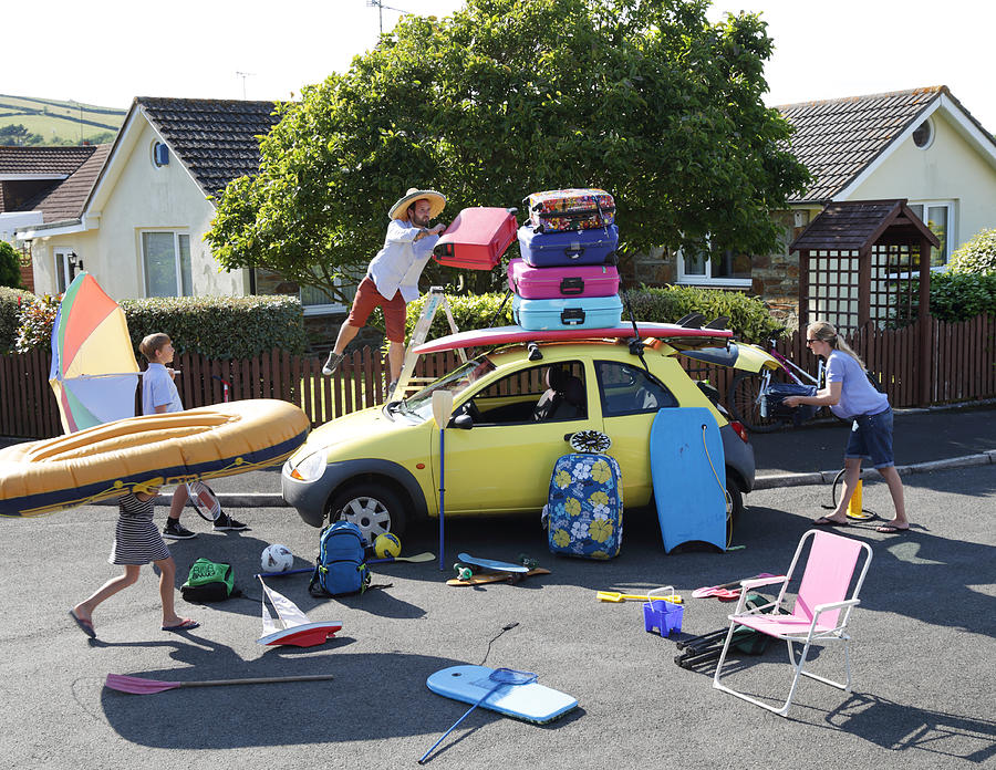 Family packing car for holiday Photograph by Peter Cade