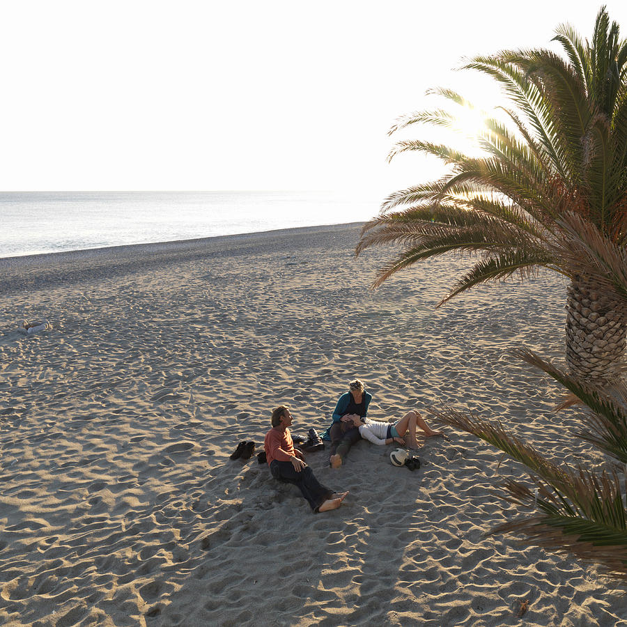 Family relaxes on empty sand beach, off-season Photograph by Ascent/PKS Media Inc.