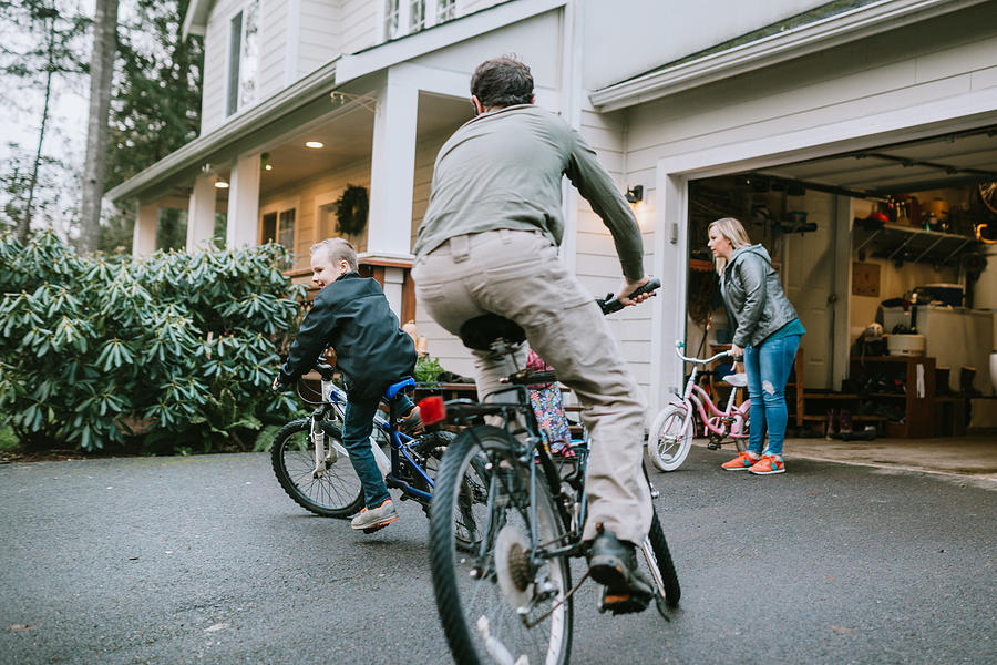 Family Riding Bikes in Home Driveway Photograph by RyanJLane