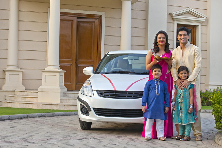 Family standing next to new car Photograph by IndiaPix/IndiaPicture