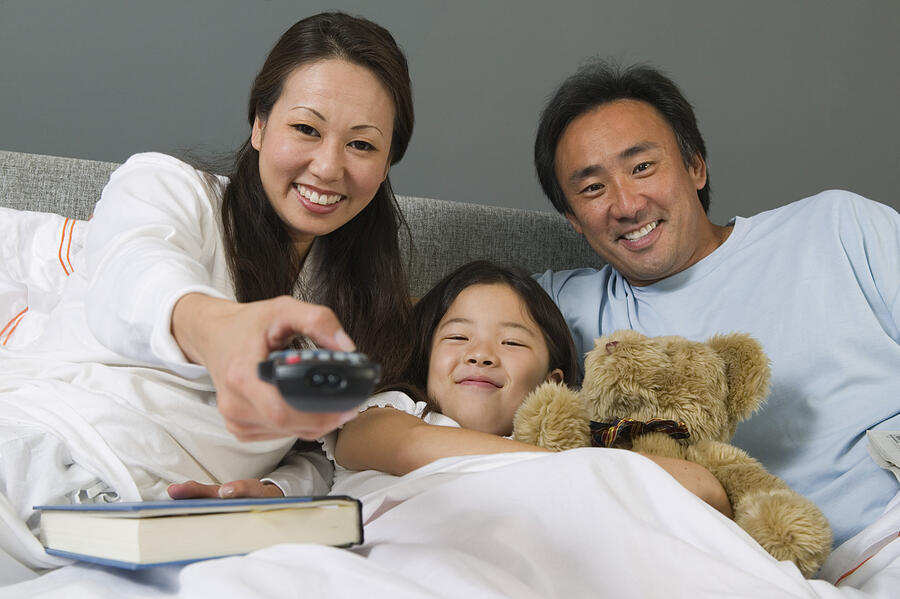 Family Watching TV Together in Bed Photograph by Moodboard