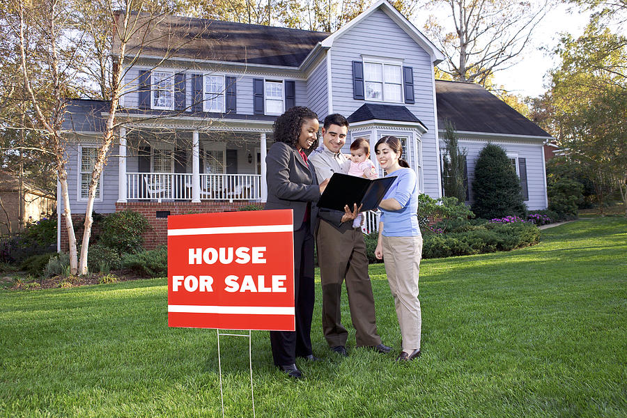 Family with real estate agent outside house Photograph by Thinkstock Images