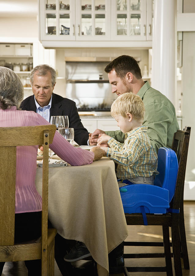 Family with son (2-3 years) saying Grace at Dinner Table Photograph by Andersen Ross
