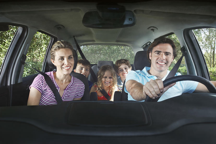 Family with three children (5-11) in car interior portrait Photograph by Moodboard