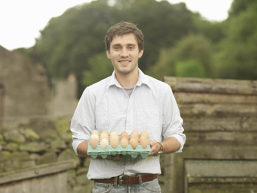 Farmer Holding A Tray Of Eggs Photograph by Monty Rakusen
