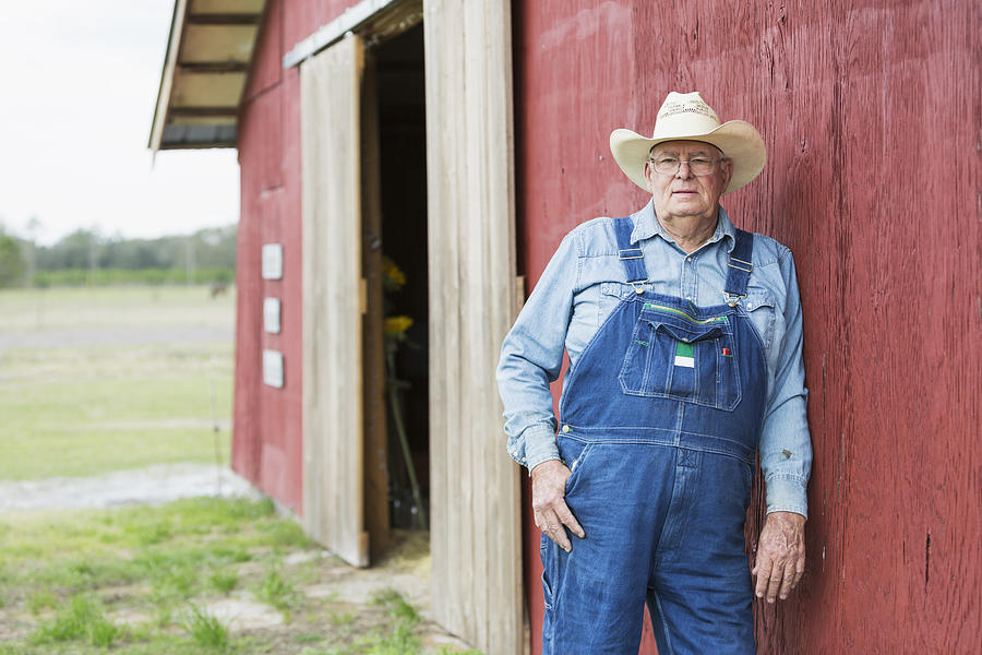 Farmer standing outside barn Photograph by Kali9