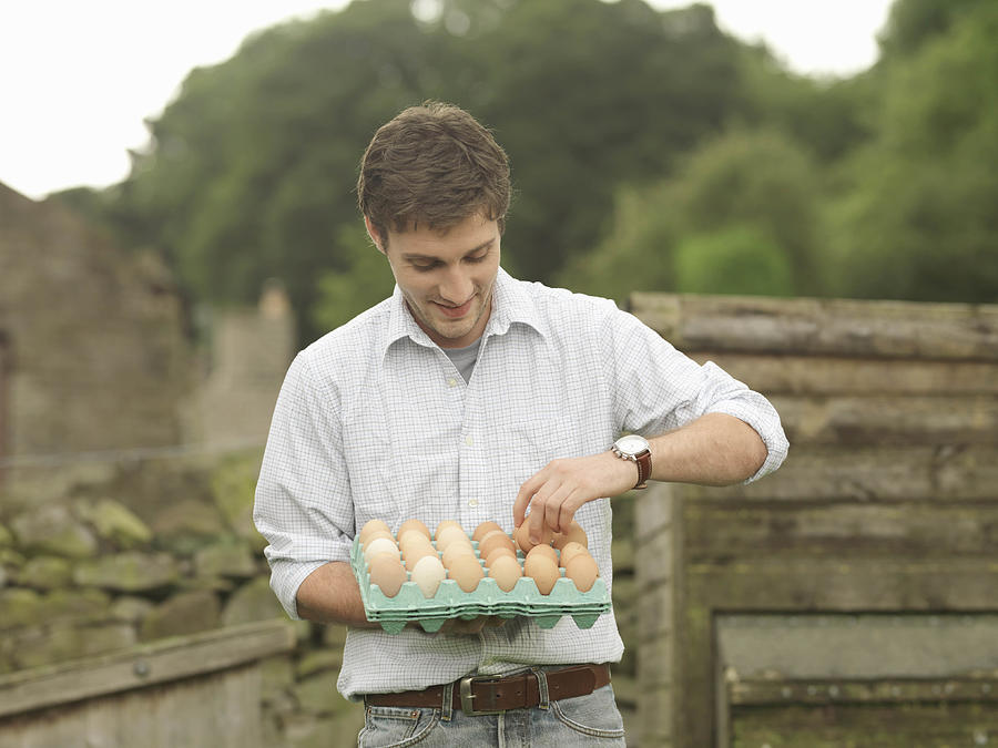 Farmer With Tray Of Eggs Photograph by Monty Rakusen