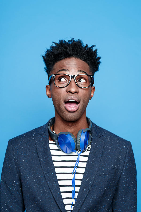 Fashionable afro american young man against blue background Photograph by Izusek