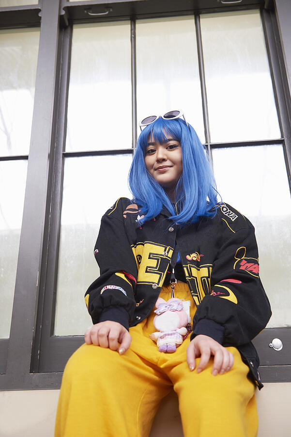 Fashionable young woman with blue hair. Photograph by We Are